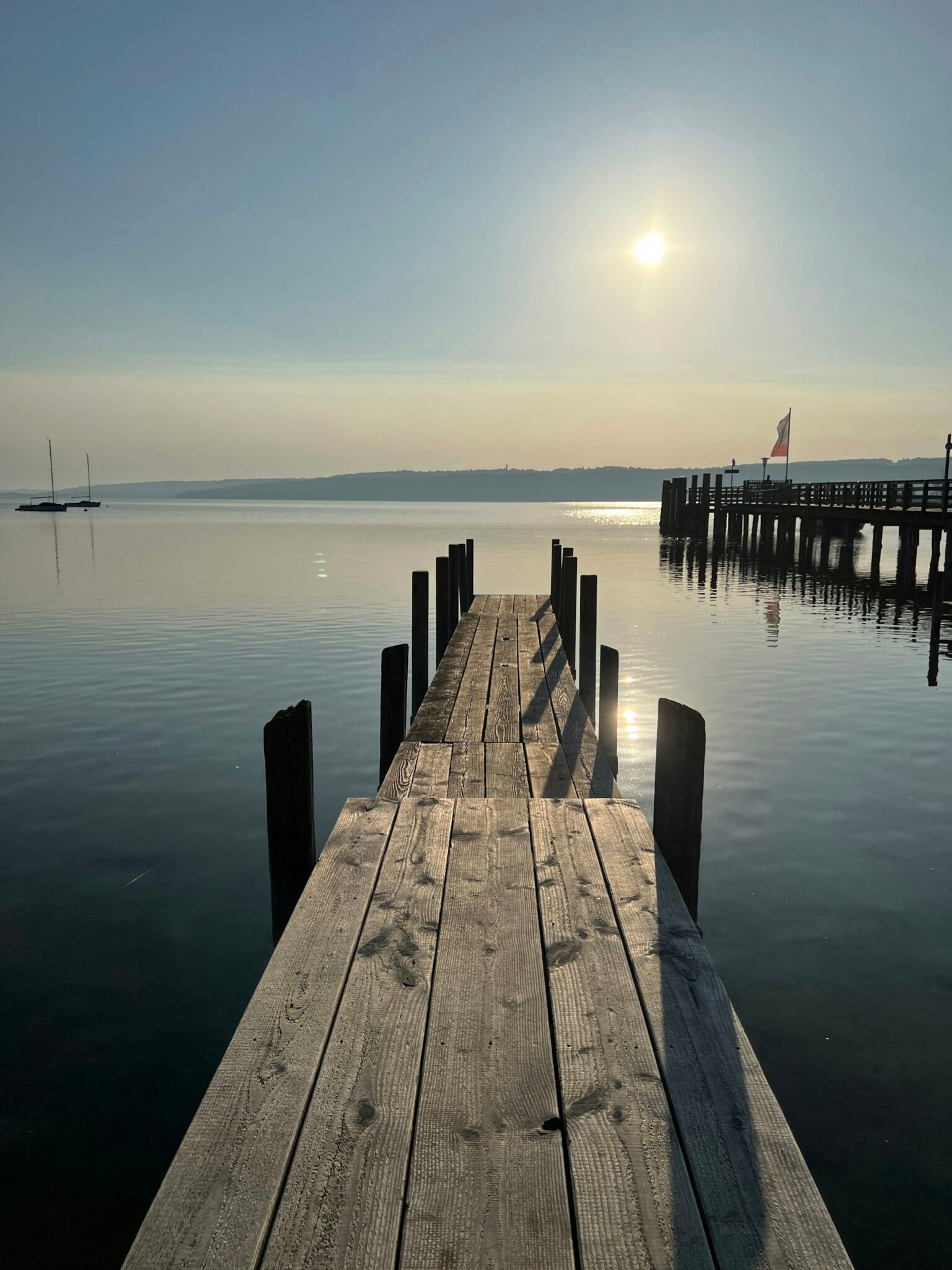 Alter Holzsteg im ruhigen Wasser des Ammersees