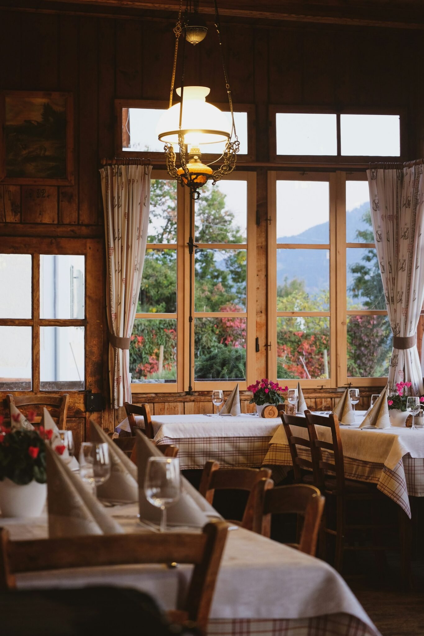 Gedeckte Tische am Fenster mit Blick ins Grüne